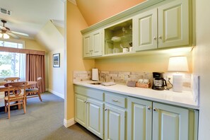 A kitchen with light green cabinets, a white countertop, and a ceiling fan. - Pool Access + Golf View: 5BR Springfield Home (Springfield)
