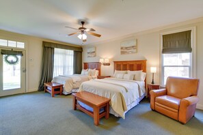 A hotel room with two beds, a wooden chair, a small table, a ceiling fan, and artwork on the walls. - Pool Access + Golf View: 5BR Springfield Home (Springfield)