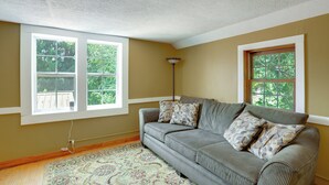 A room with a sofa, two windows, a patterned rug, and a ceiling light. - On Horse Farm! Home w/ Pond Access in Spring Creek (Spring Creek)