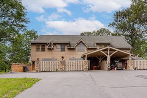 A two-story building with a covered garage and a stone wall.