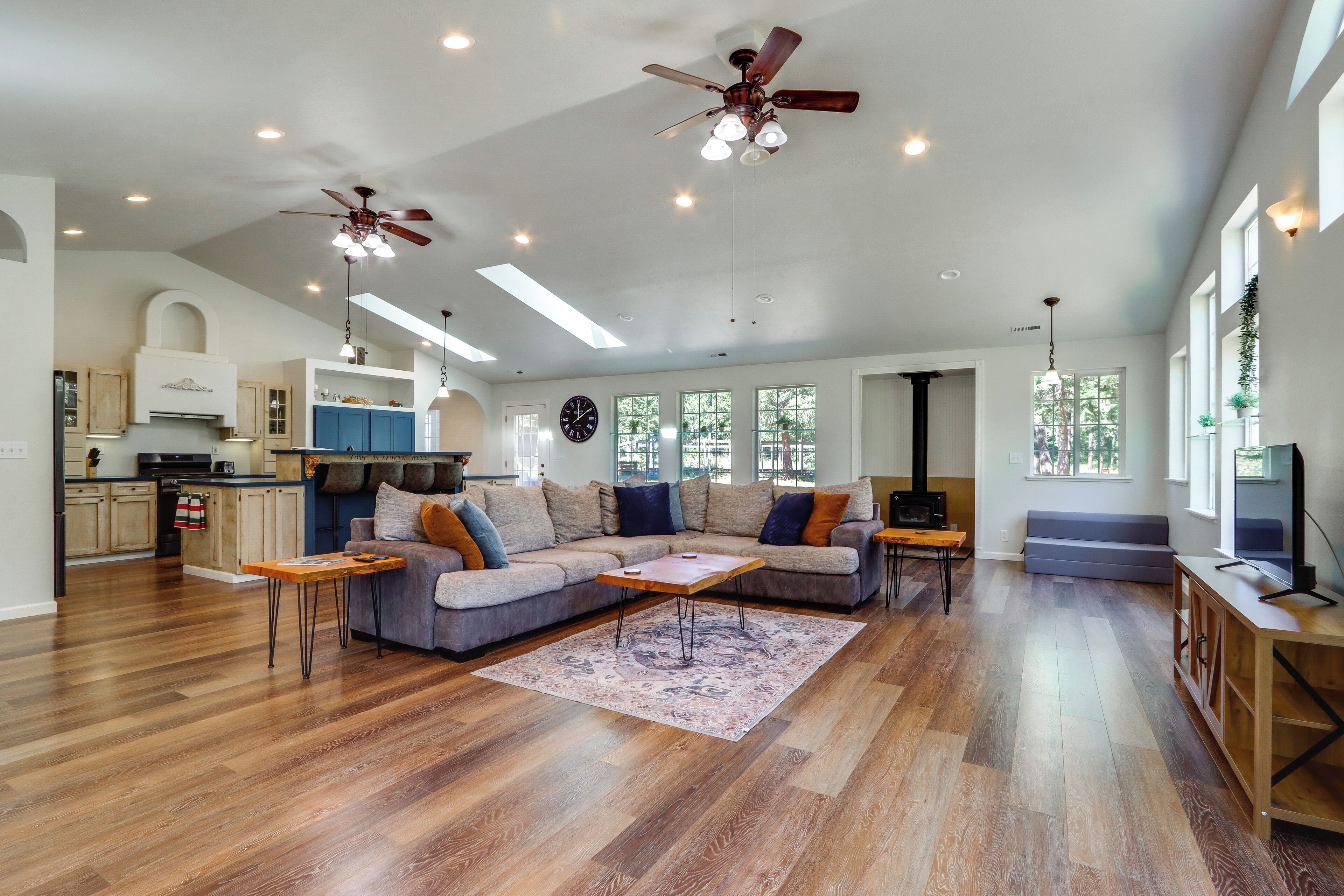 A spacious living area with a large sofa, a coffee table, and a ceiling fan.