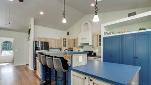 A modern kitchen with a blue countertop, bar stools, and a built-in oven. - Riffle Road Ranch: 10 Acres, 8 Mi to Silverwood (Spirit Lake)