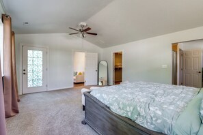 A bedroom with a bed, a ceiling fan, and a door leading to a closet.