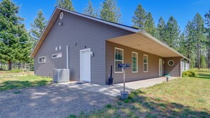 A two-story building with a covered porch, a gravel driveway, and a sign indicating a no parking zone. - Riffle Road Ranch: 10 Acres, 8 Mi to Silverwood (Spirit Lake)
