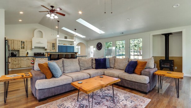 A modern living room with a sectional sofa, wooden coffee table, and a large rug. - Riffle Road Ranch: 10 Acres, 8 Mi to Silverwood (Spirit Lake)