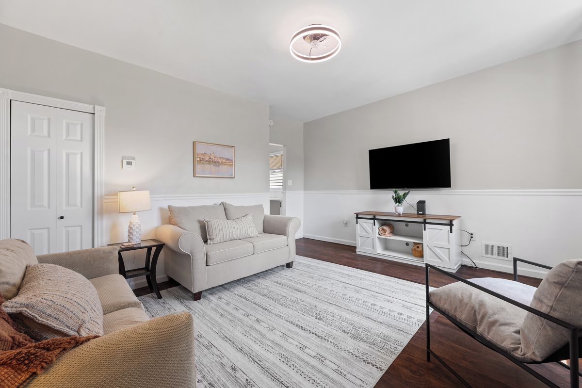 Bright, cozy living room with wall-mounted TV and stylish seating