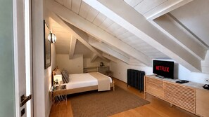 A bedroom with a bed, bedside table, lamp, and a TV displaying 'NETFLIX'. - Ponte degli Alpini | Luxury Penthouse · Sauna, 2 Hot Tubs & Panoramic Terrace (Bassano del Grappa)