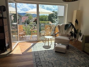 A room with a sliding glass door leading to a balcony with outdoor furniture and a view of a mountain. - Vacation Home in Creutzig on Lake Constance - Families, Friends & Relaxation, 8–10 People (Stockach)