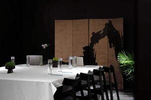 Una mesa de comedor con sillas, botellas de agua y una pequeña planta.