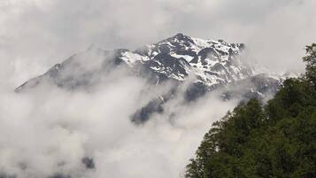 Une montagne dont les sommets enneigés sont partiellement cachés par les nuages.