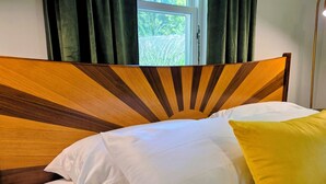 A bed with a wooden headboard, white bedding, and a yellow pillow. - Escape the hustle and reconnect with nature at Outpost, your stay tucked along the borders of Shawnee State Forest. Whether you're seeking a solo retreat, a romantic getaway, or a  weekend with friends, this spot offers a blend of woods & comfort. (West Portstmouth)