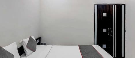 Un dormitorio con cama, almohadas, un armario y un ventilador de techo.