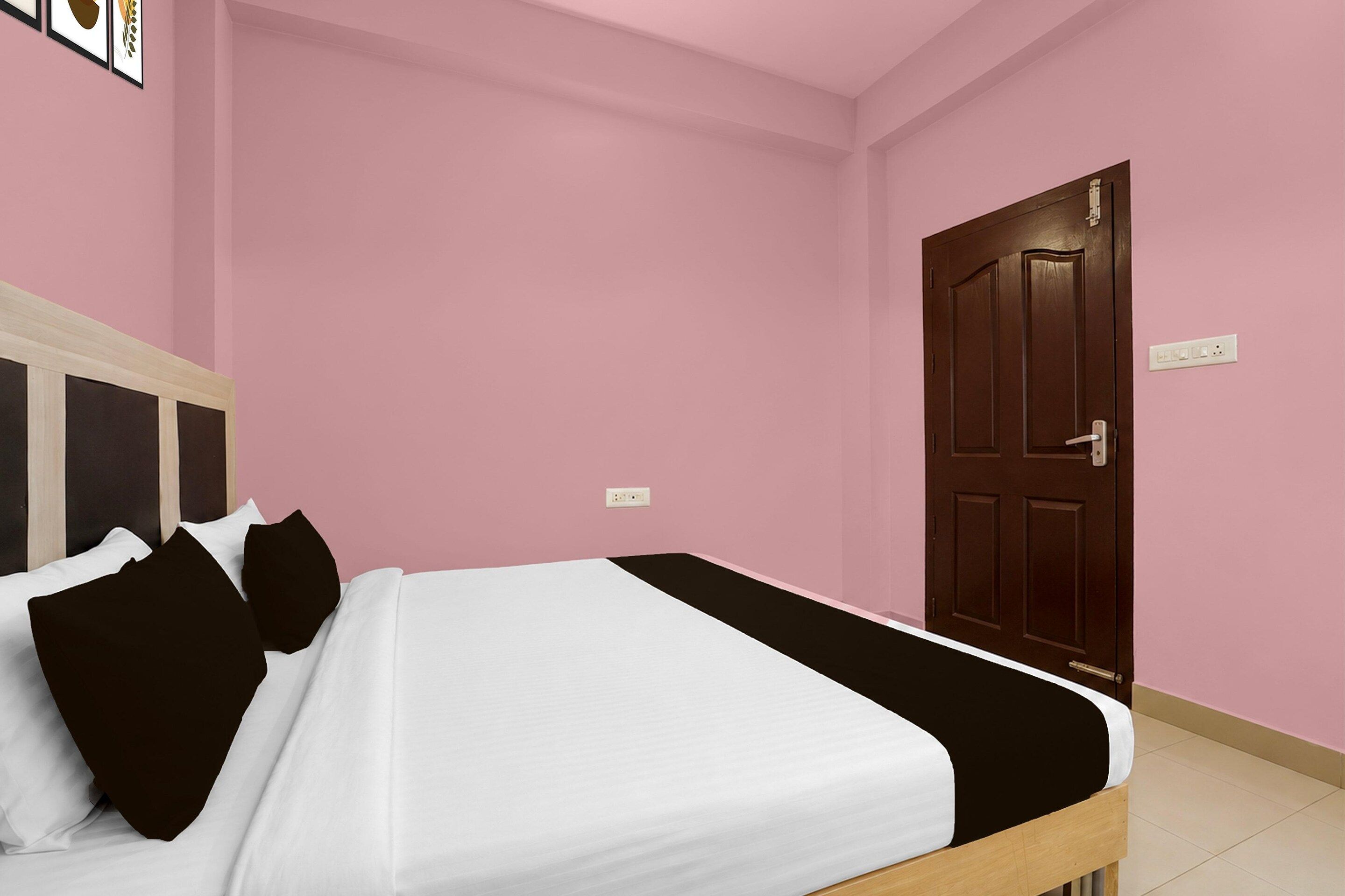 A room with a bed, a door, and a wall socket.