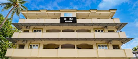 A multi-story hotel building with a sign indicating it is serviced by OYO.