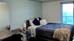 A bedroom with a bed, desk, and a window. - Penthouse in the Sky (Waterloo)
