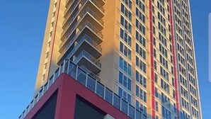A modern building with a prominent red and white facade, large windows, and a clear sky. - Penthouse in the Sky (Waterloo)