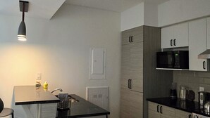 A modern kitchen with a central island, built-in appliances, and a minimalist design. - Penthouse in the Sky (Waterloo)