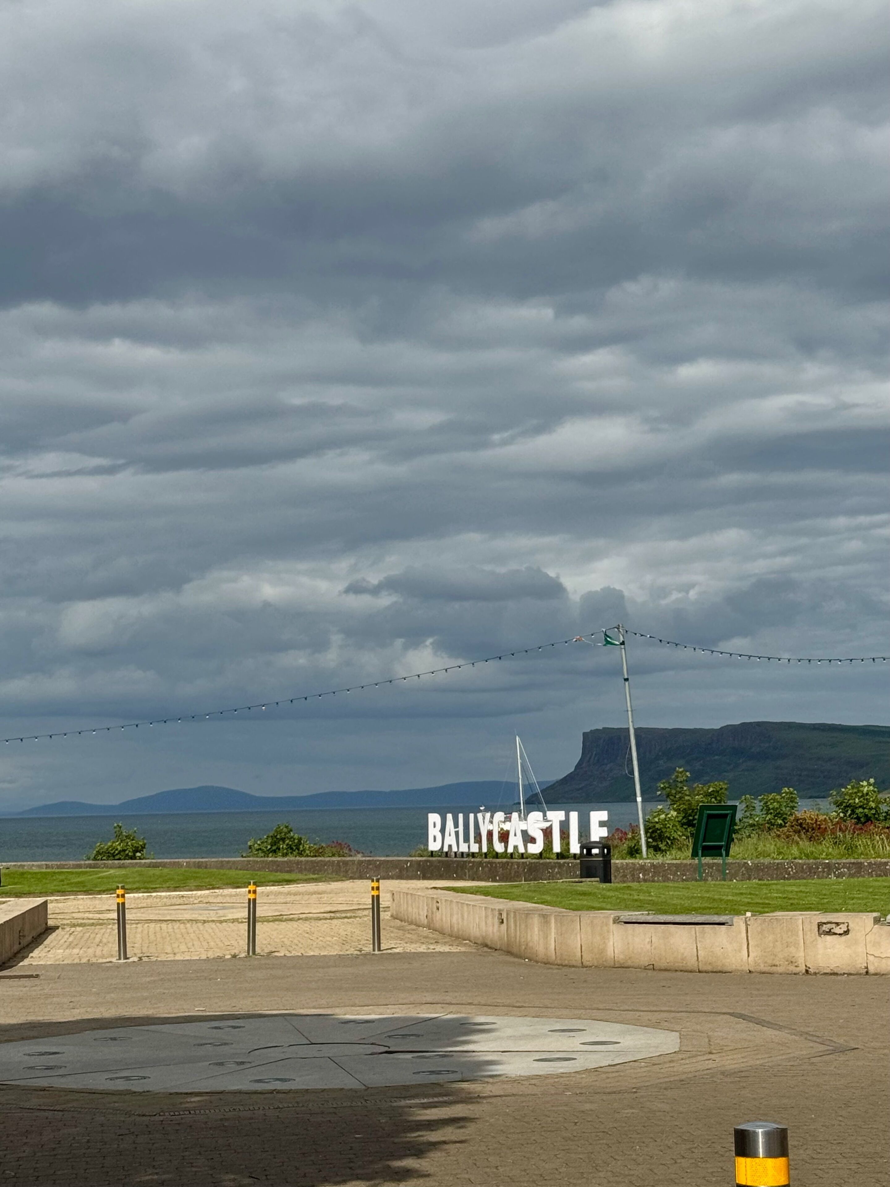 A view of Ballycastle with a sea and mountains in the background.
