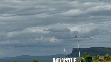 A view of Ballycastle with a sea and mountains in the background.