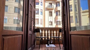 An open balcony with two chairs and a table, a bottle of wine, and a glass. - Apartment in downtown Valencia, close to everything (València)