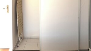 Ein Zimmer mit Schiebetüren zum Kleiderschrank, einem Handtuchhalter und einer Kleiderstange.