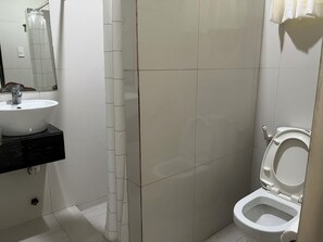 Ein Badezimmer mit einem weißen Waschbecken, einer Toilette und einem Spiegel an der Wand.