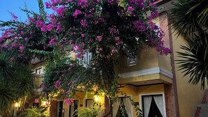 A building with a balcony, potted plants, and a sign indicating room numbers. - Puerto Del Sol Beach Resort and Hotel Club Bolinao (Bolinao)