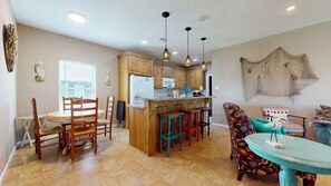 A kitchen with wooden cabinets, a central island, and hanging pendant lights. - Turtlely Relaxed: 3  BR, 2  BA House in Crystal Beach, Sleeps 10 (Crystal Beach)