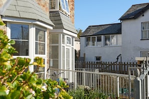 A residential area with houses featuring bay windows and a wooden fence. - Elegant Riverside Apartment for 4 (Bude)