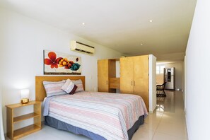Ein Schlafzimmer mit Bett, Nachttisch, Kleiderschrank und einem Bild an der Wand.