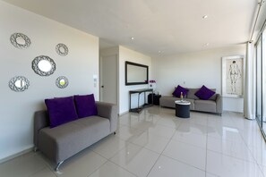 Ein modernes Wohnzimmer mit einer Couch, einem Couchtisch und dekorativen Spiegeln an den Wänden.