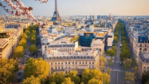A cityscape with the Eiffel Tower in the background, surrounded by dense urban buildings and streets. - Bel Appartement 10 Minutes Pied de la Tour Eiffel (Paris)