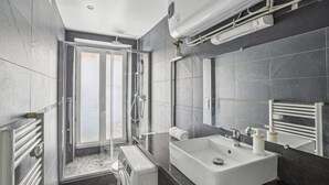 A modern bathroom with a glass shower enclosure, a built-in sink, and a large mirror. - Bel Appartement 10 Minutes Pied de la Tour Eiffel (Paris)