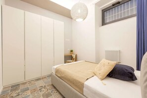 A bedroom with a bed, a wardrobe, a desk, and a radiator. - Athens House • Near the Duomo [Loreto-Duomo] (Milano)