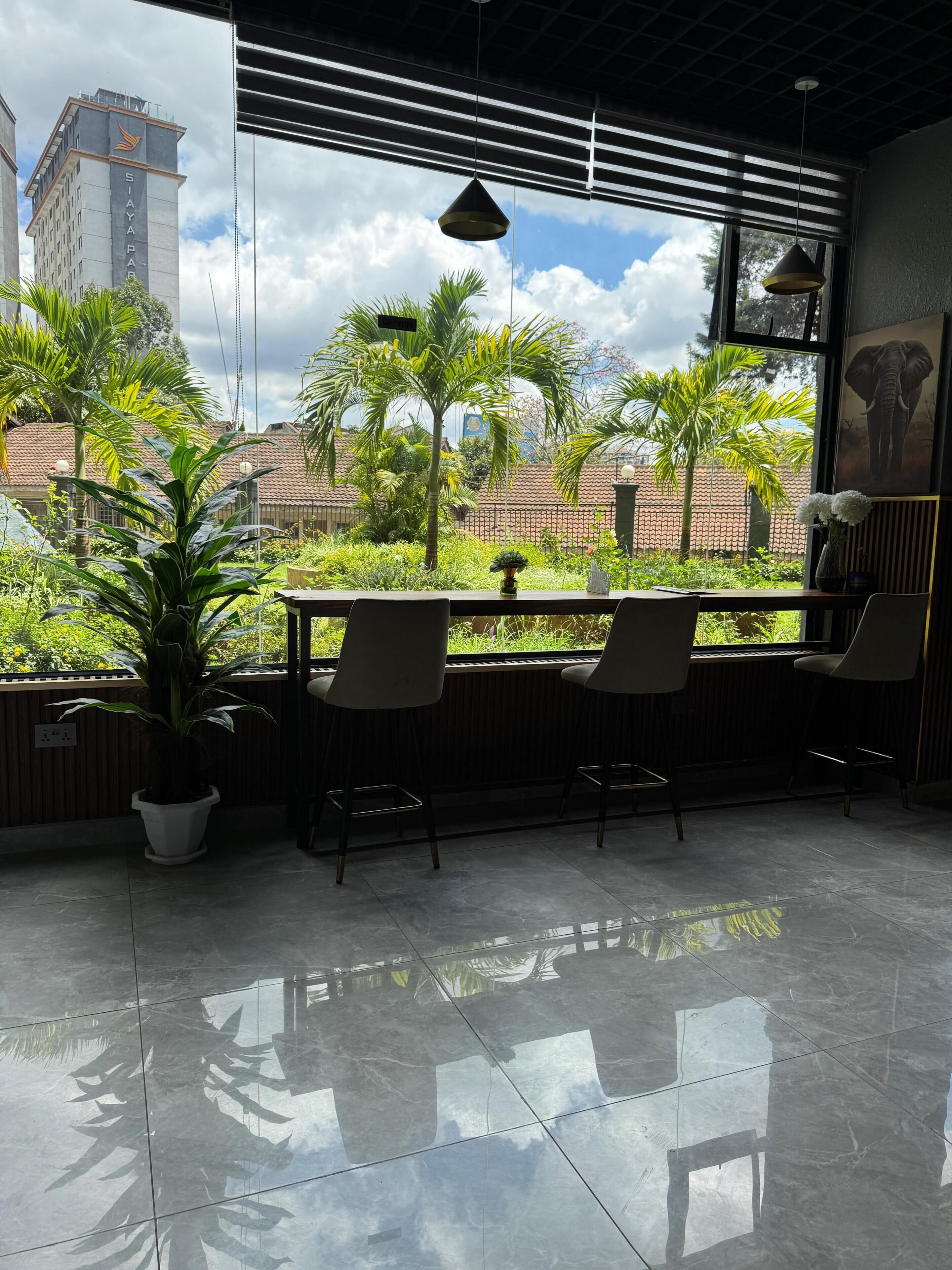 Een modern interieur met een groot raam met uitzicht op een tuin en een stadsbeeld.