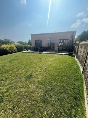 A building with a flat roof, large windows, and a deck area. - BELLEVUE COTTAGE (Tréveneuc)