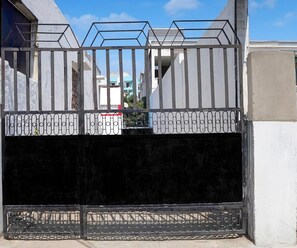 A gated entrance with a metal gate and a concrete wall. - Hotel O Singar Nagar Metro Station Lucknow (Lucknow)