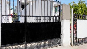 A gated entrance with a metal gate and decorative metalwork. - Hotel O Singar Nagar Metro Station Lucknow (Lucknow)