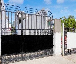 Ein verschlossenes Tor mit einem Metallgitter und schmiedeeisernen Verzierungen.