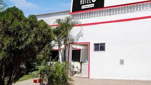 A hotel named 'HOTELO' with a company-serviced sign, a red and white facade, and a doorway leading to the entrance. - Hotel O Singar Nagar Metro Station Lucknow (Lucknow)