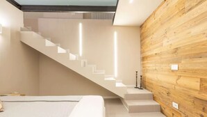 Ein modernes Schlafzimmer mit Treppe, Bett und einer Wand aus Holz.