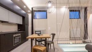 Eine moderne Küche mit dunklen Schränken, einem Holztisch und einer Bank.