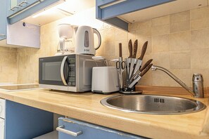 Eine Küche mit Mikrowelle, Toaster und Spüle.