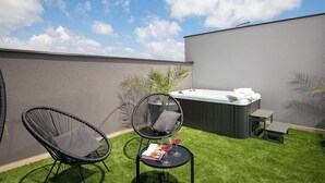 A rooftop terrace with two black wicker chairs, a small round table with a magazine and two wine glasses, a hot tub, and a bench. - Villa PalmDora – New Vacation Home with Private Pool & Hot Tub in Istria (Marčana)