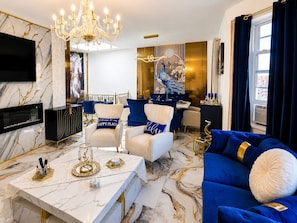 A luxurious living room with a marble floor, a chandelier, a sofa, and a dining area with a table set for two. - Royal 3-bedroom apartment/Wifi/15 min NYC/Bus stop 2 min/8 people (West New York)