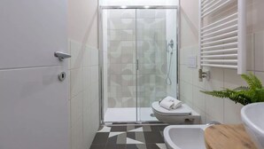 Une salle de bain moderne avec une douche à parois de verre, des toilettes et un lavabo.
