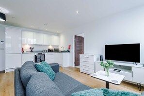 A modern living room with a grey sofa, a flat-screen TV, and a coffee table. - NEW! Chic City Base - Old Trafford & MediaCityUK (Stretford)