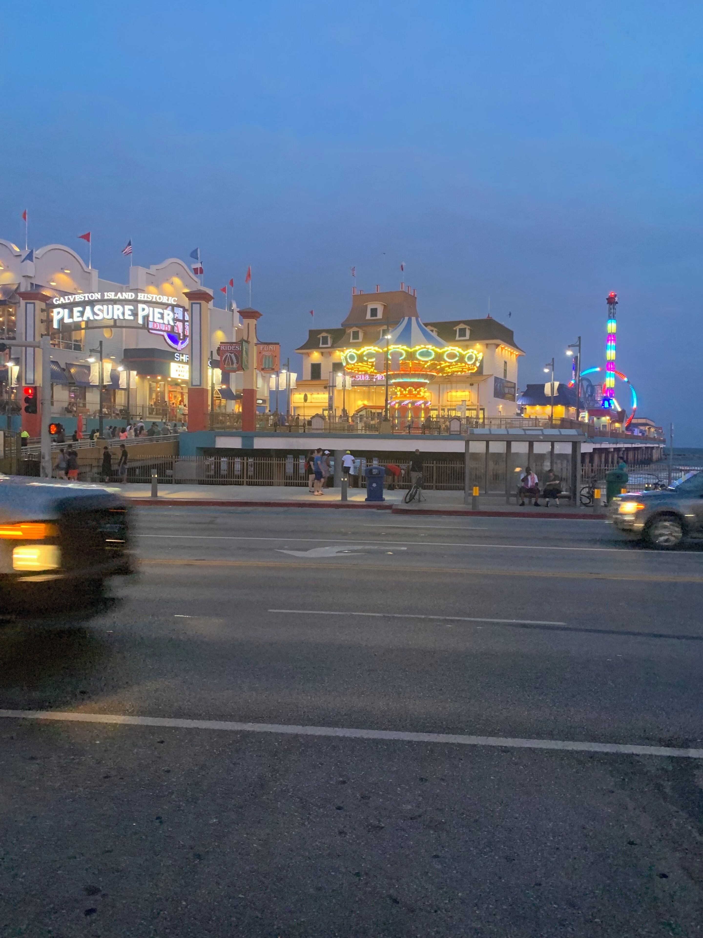 A historic pier with a carousel and a tall illuminated structure.