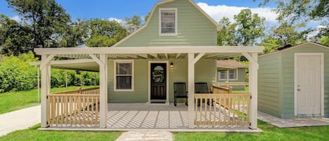 A two-story house with a porch, a small attached garage, and a pathway leading to the entrance.
