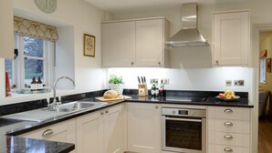 Una cocina moderna con gabinetes blancos, una encimera negra y un horno empotrado.